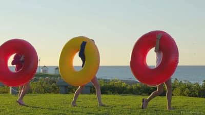 a man is doing a handstand on two giant inflatable donuts