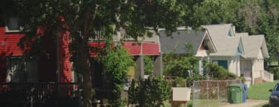 a row of houses with a car parked in front of them