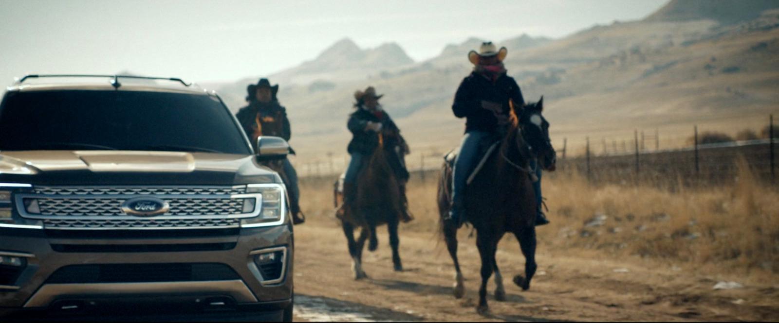 a group of people riding horses next to a truck