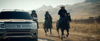a group of people riding horses next to a truck
