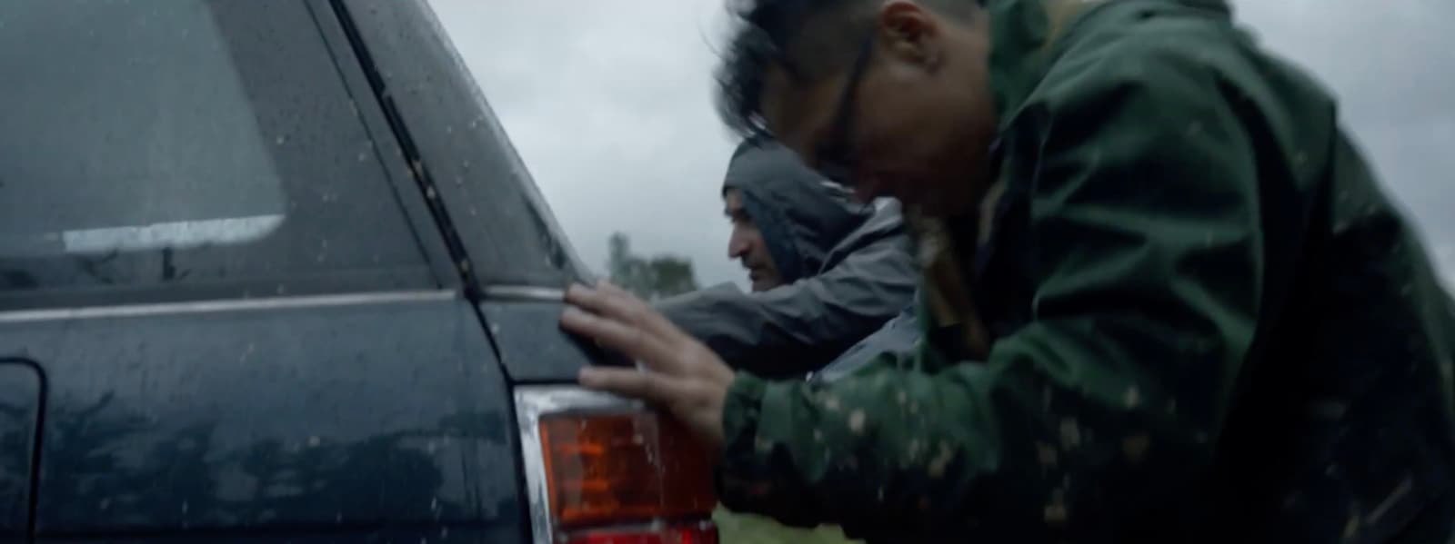 a man leaning on the back of a car