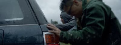 a man leaning on the back of a car