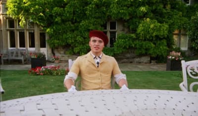 a man sitting at a table in front of a house