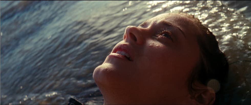a woman laying in the water with her eyes closed