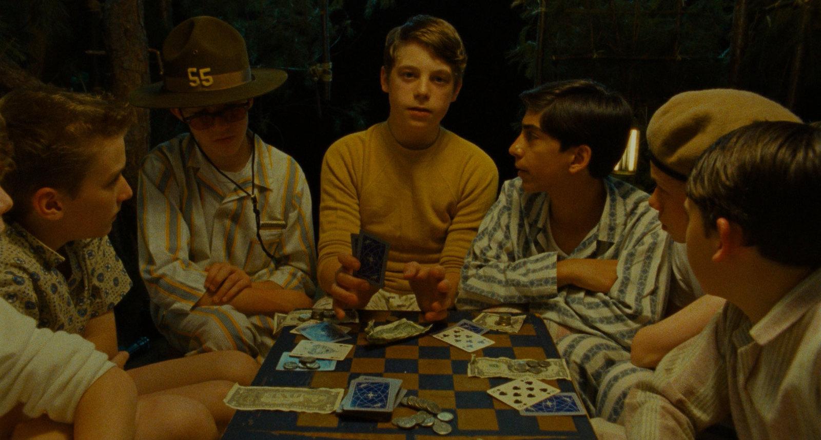 a group of young men sitting around a table playing cards