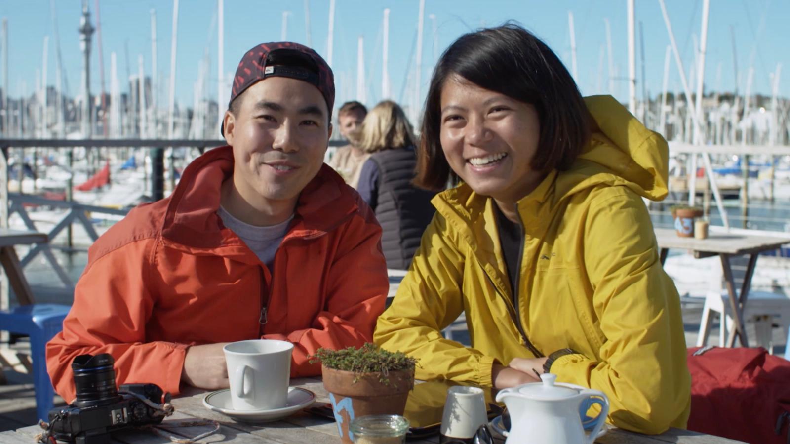 two people sitting at a table with cups of coffee