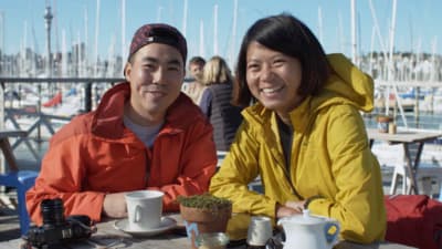 two people sitting at a table with cups of coffee