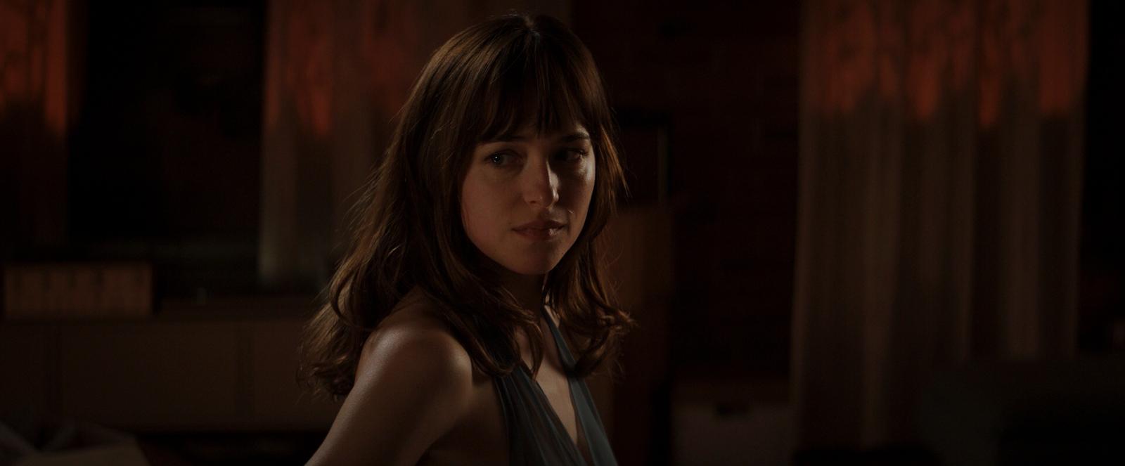 a woman with long hair standing in a dark room