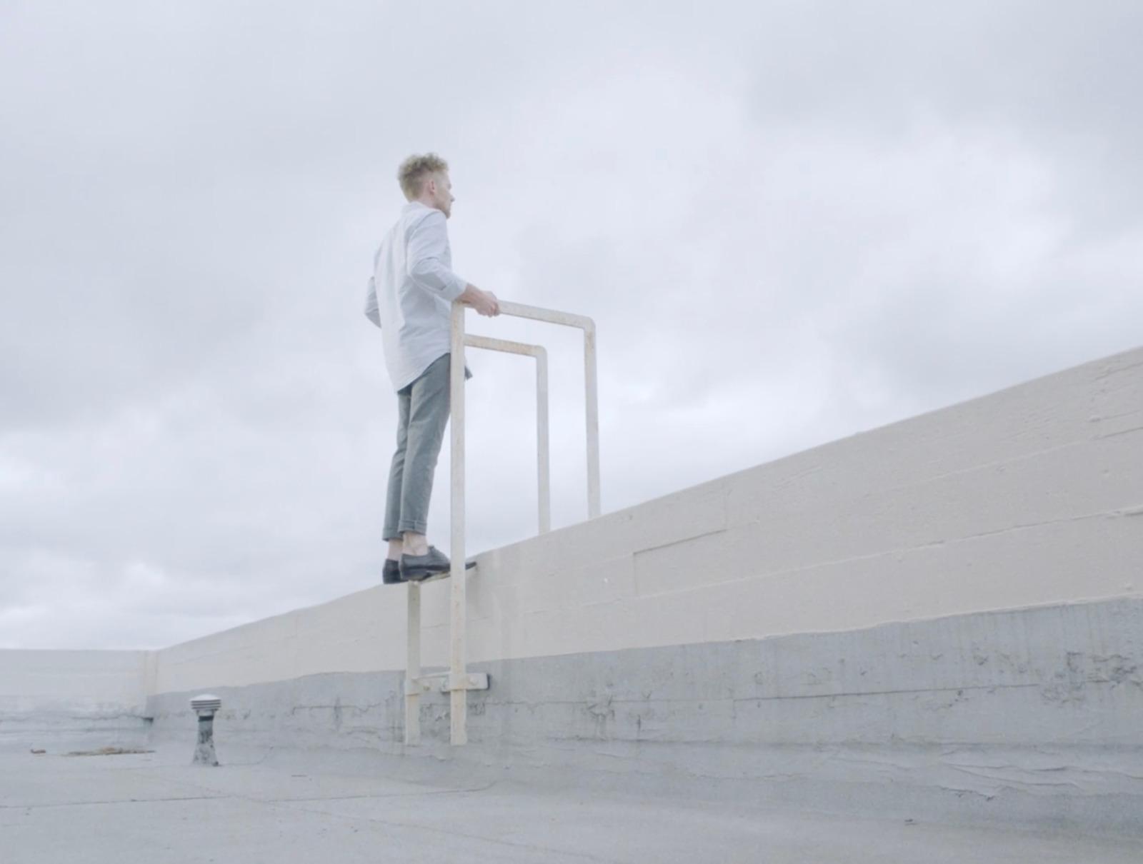a man standing on a ladder on a cloudy day