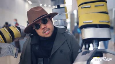 a man wearing a hat and sunglasses standing in front of luggage