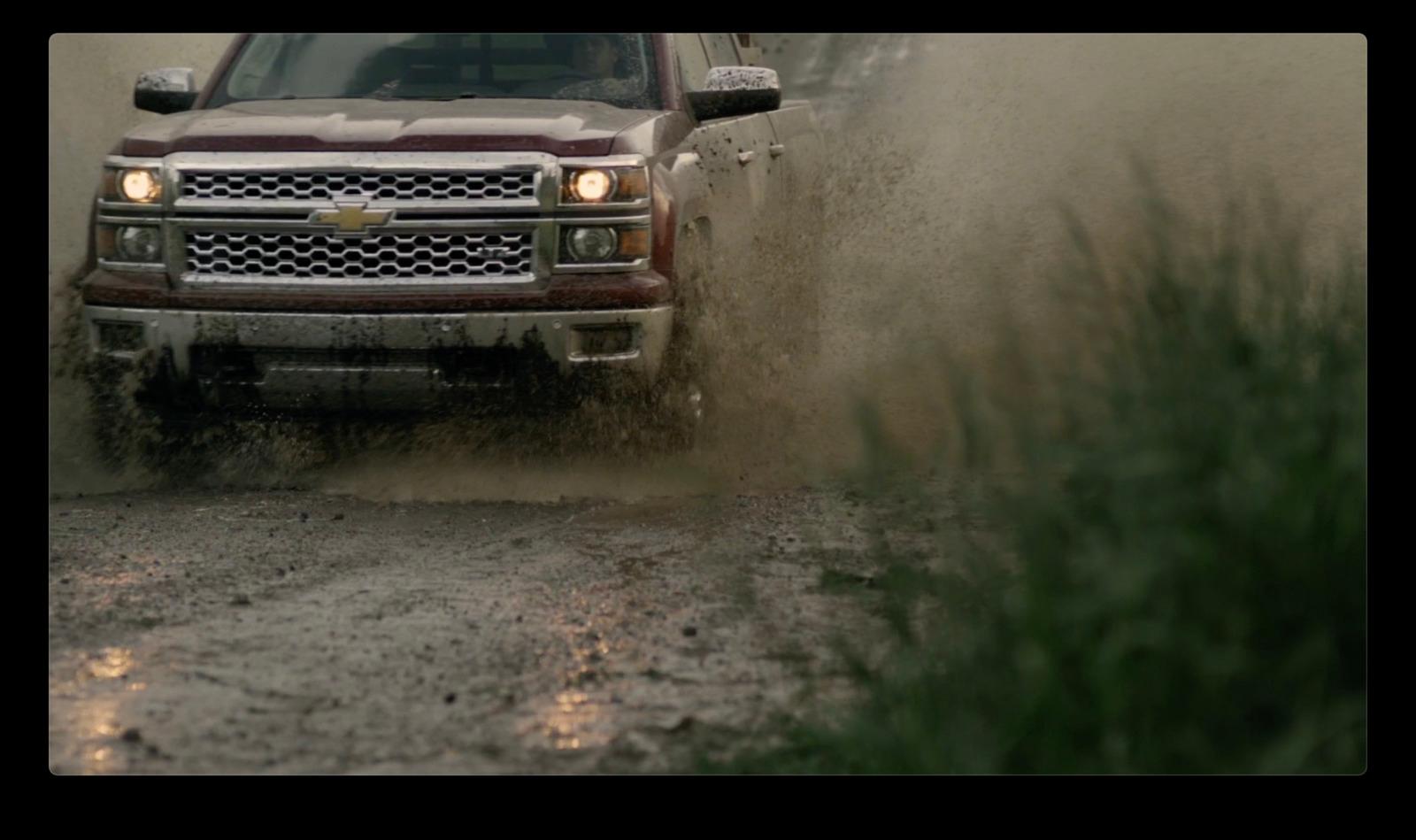 a truck driving through a puddle of mud