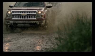 a truck driving through a puddle of mud