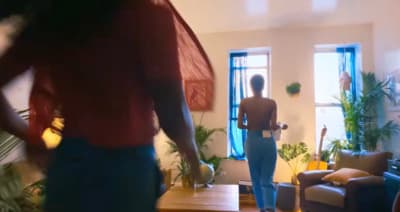 a woman standing in a living room next to a couch