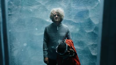 a man standing in front of an ice cave
