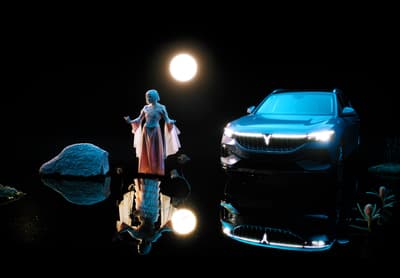 a woman standing next to a car in the dark