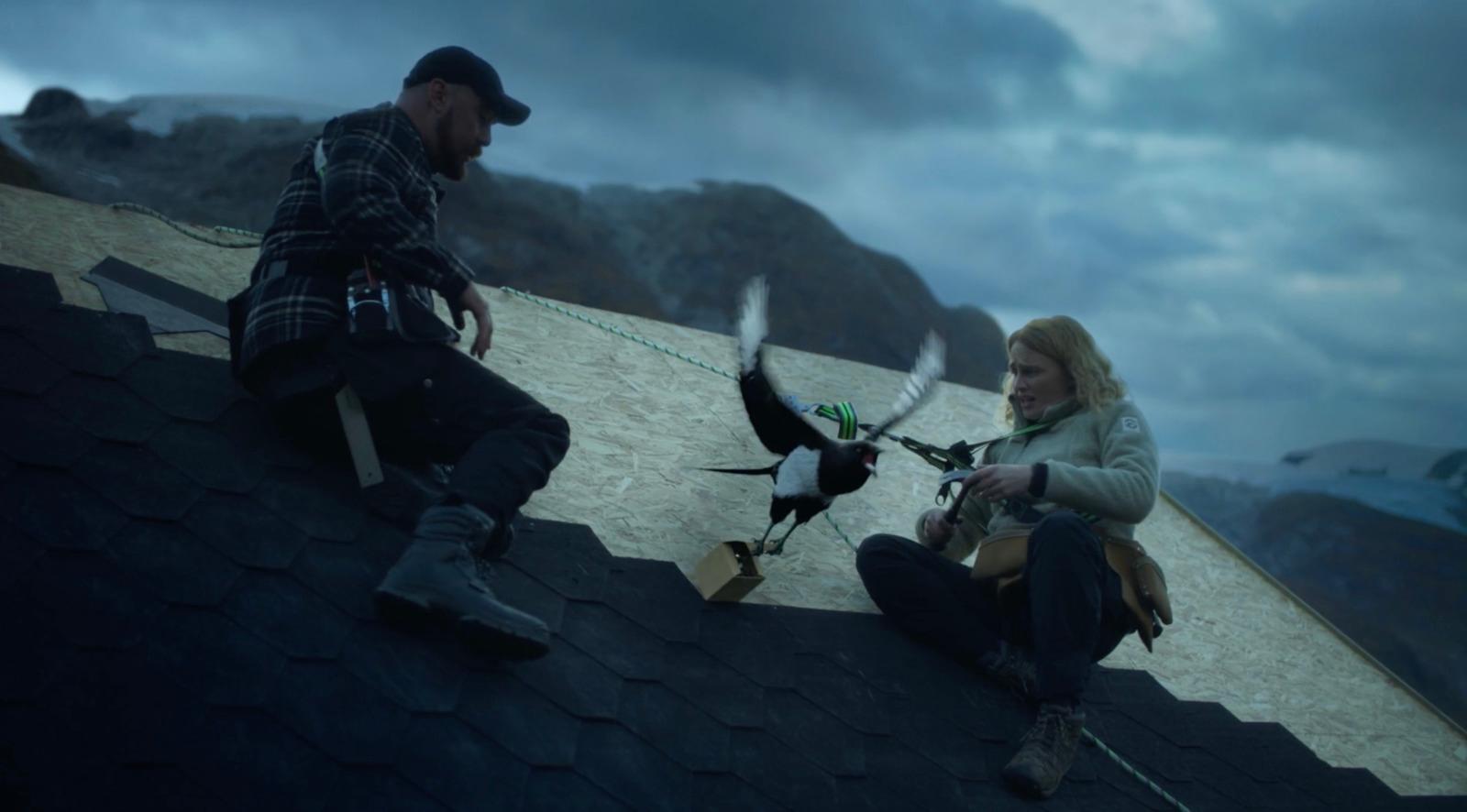 a man and a woman sitting on a roof