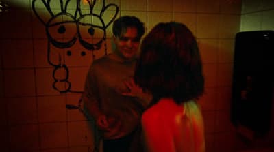 a man and a woman standing in a bathroom