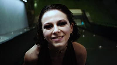 a woman with long black hair smiling at the camera
