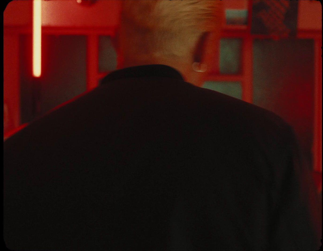a man standing in front of a red wall