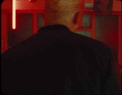 a man standing in front of a red wall