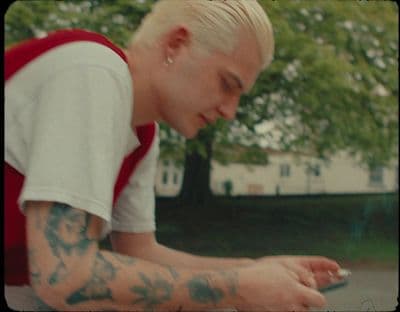 a man with a tattoo on his arm looking at a cell phone