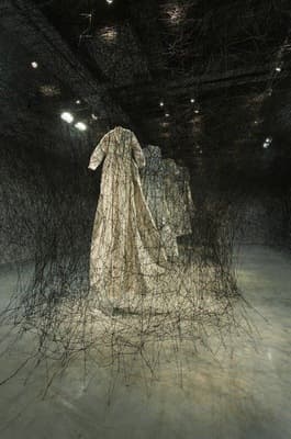 a sculpture of a woman standing in a dark room