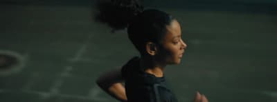 a young woman is running in a dark room