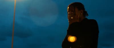 a woman standing under a street light talking on a cell phone