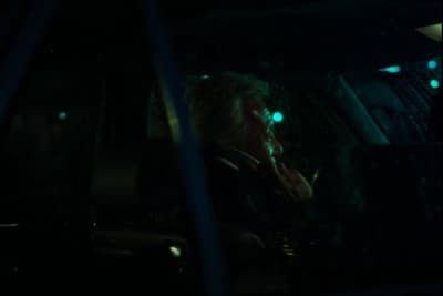 a woman sitting in a car talking on a cell phone