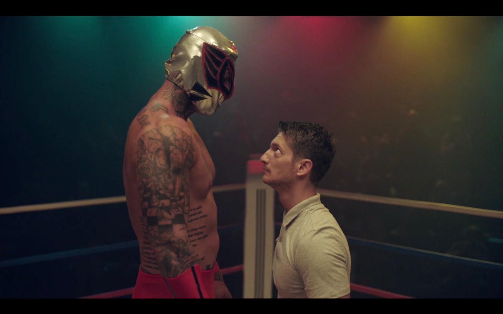 a man standing next to a wrestler in a ring