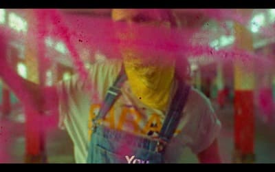 a man wearing overalls and a yellow bandana