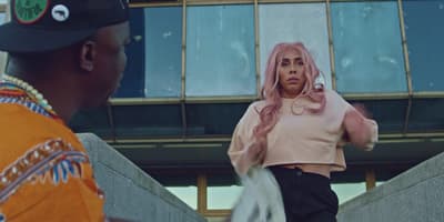 a woman with pink hair is standing next to a man
