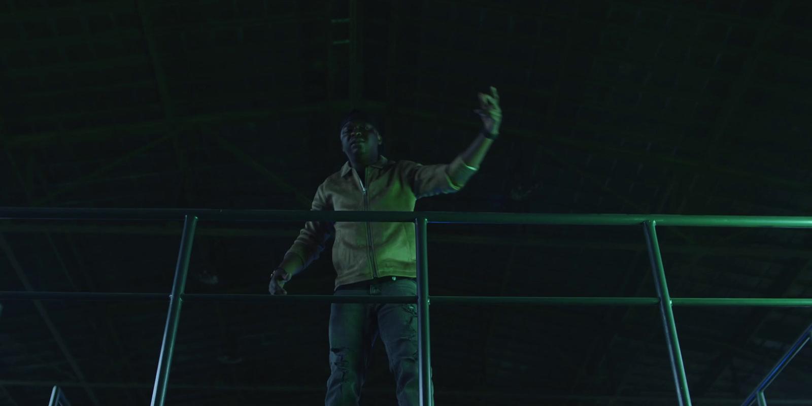 a man standing on a railing in a dark room
