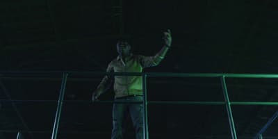 a man standing on a railing in a dark room