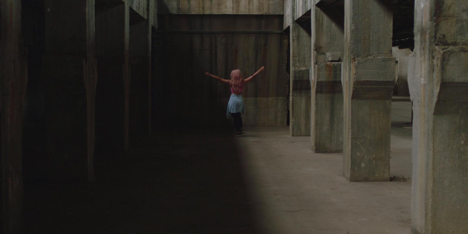 a girl is standing in a hallway with wooden beams