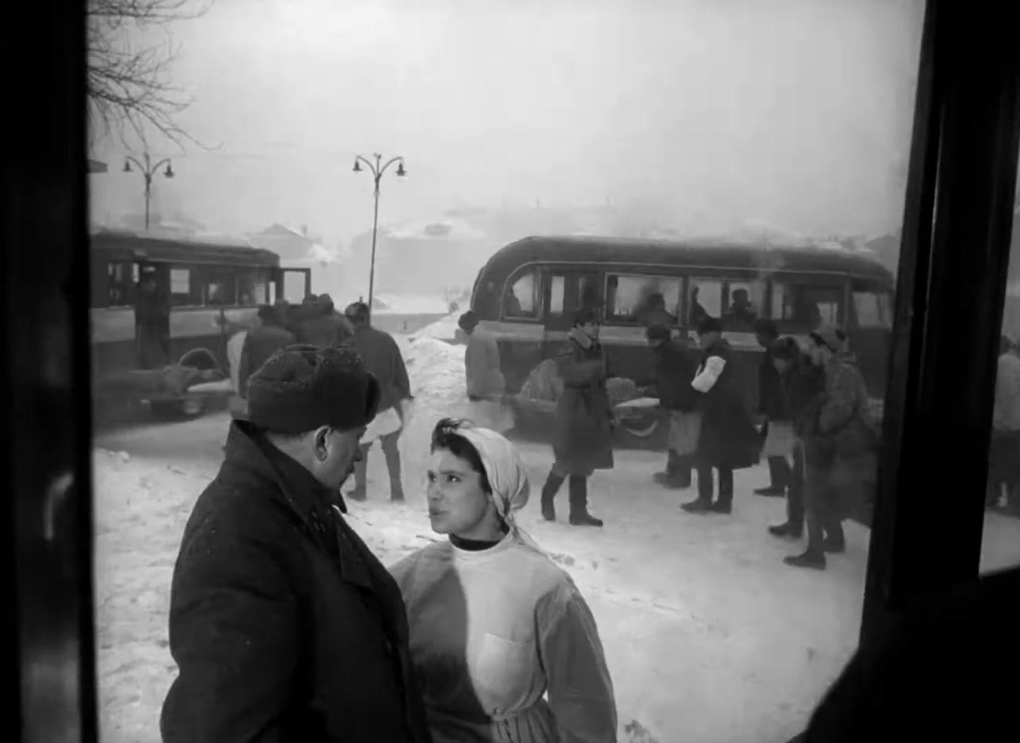 a black and white photo of a man and a woman standing in front of a