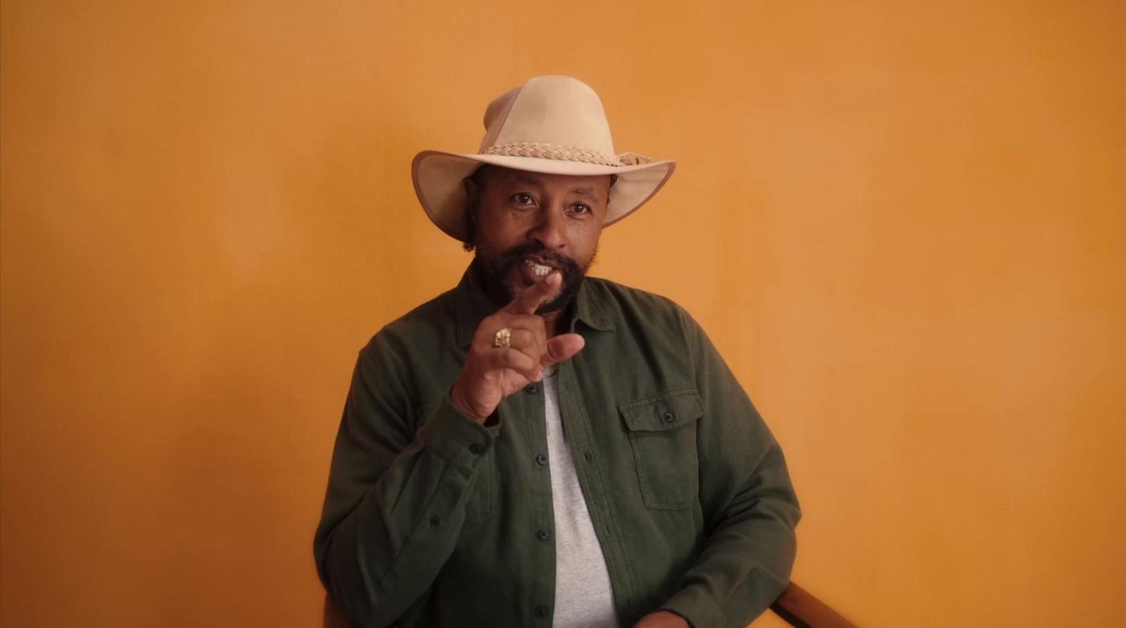 a man in a cowboy hat poses for a picture