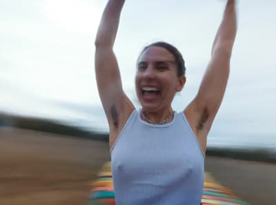 a woman holding a frisbee up in the air