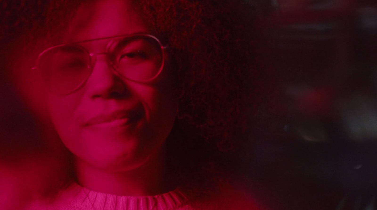 a woman with glasses looking at the camera