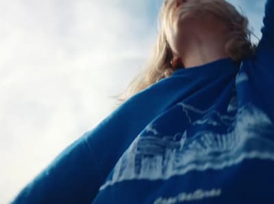 a woman holding a frisbee under a blue sky
