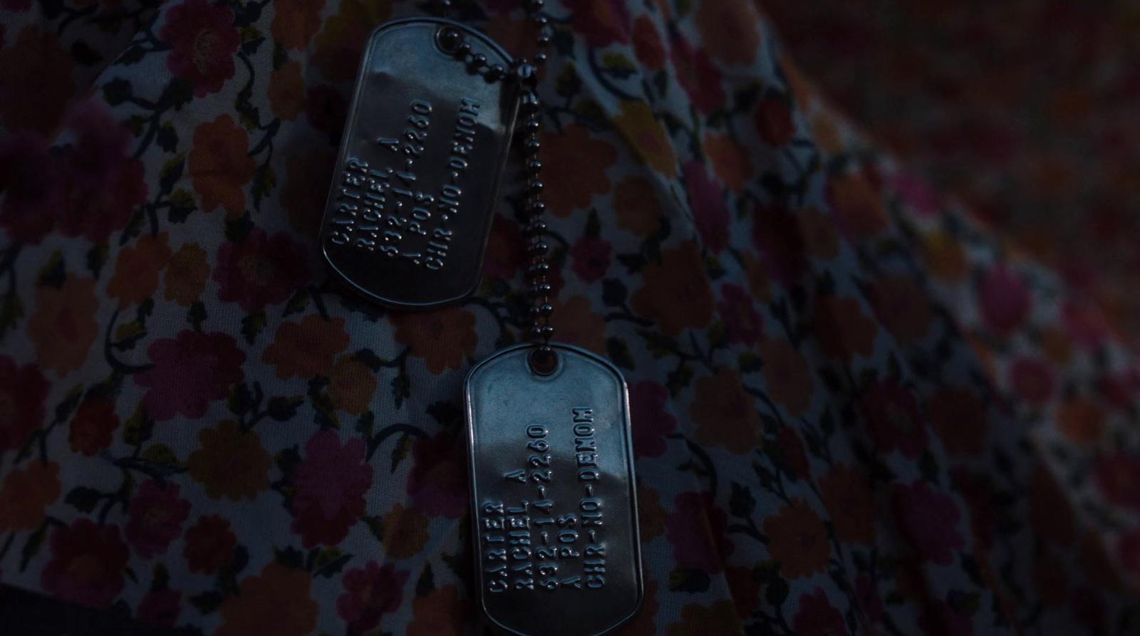 two dog tags hanging from a chain on a wall