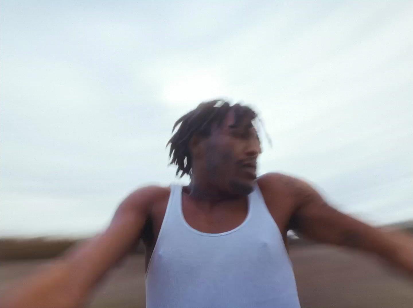 a man in a white tank top holding a white frisbee