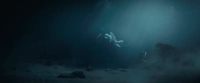 a person floating in the water in the dark