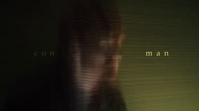 a blurry image of a woman's face with the words con man in