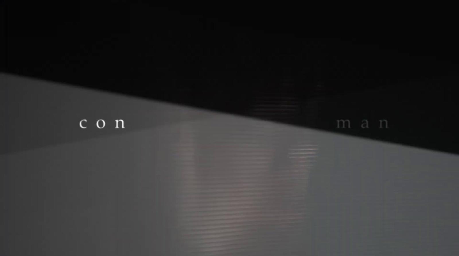 a black and white photo with the words con man on it
