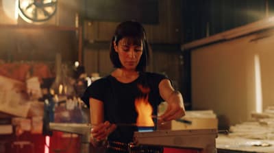 a woman standing in a kitchen preparing food