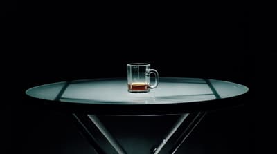 a glass of beer sitting on top of a table