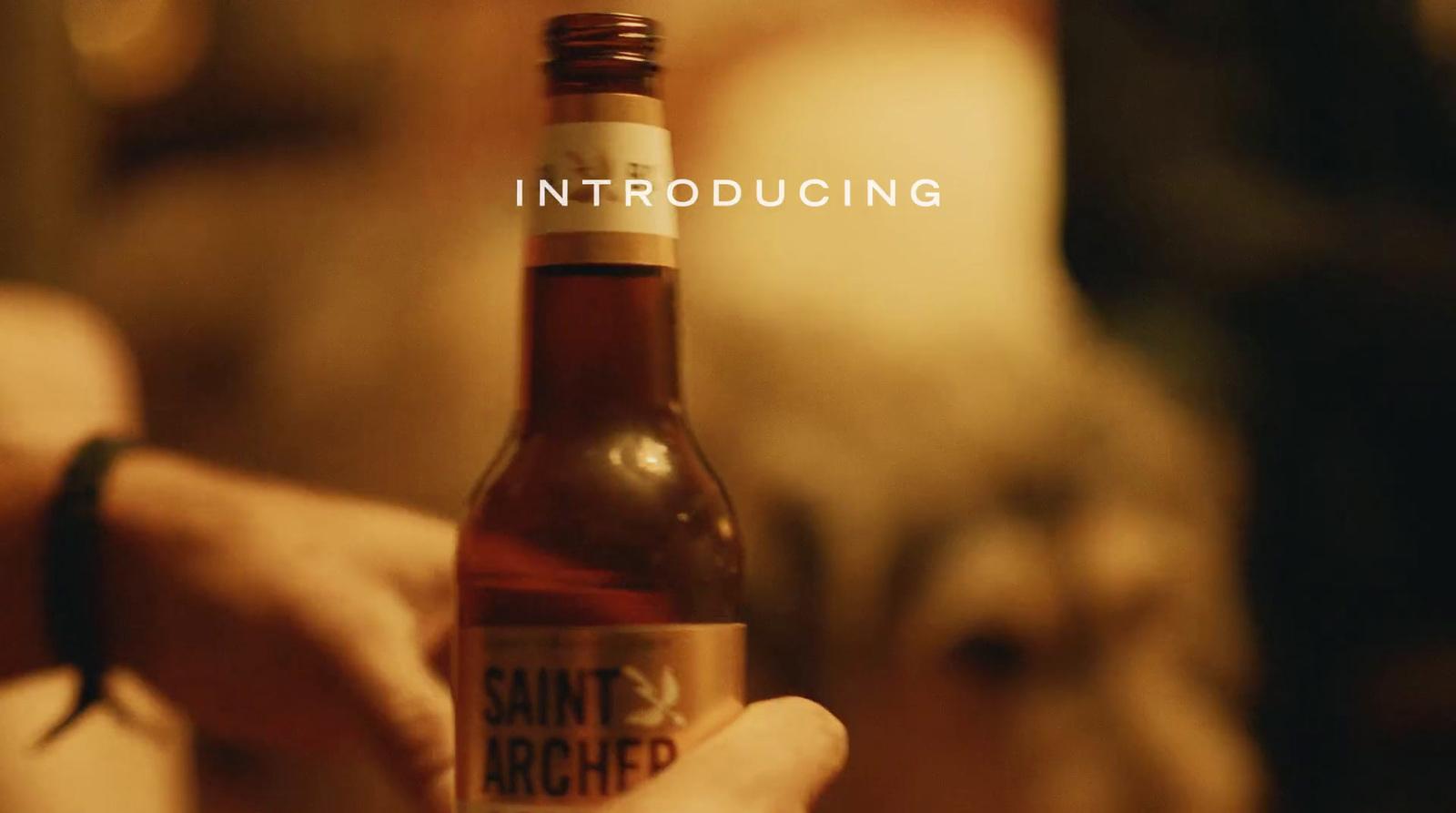 a person holding a bottle of beer in their hand