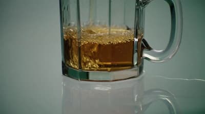 a glass mug filled with liquid on top of a table