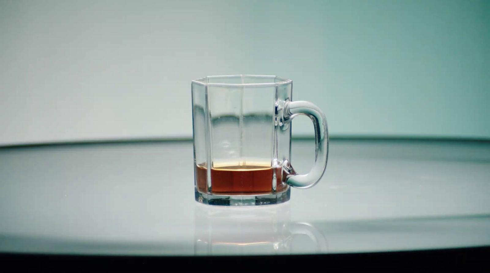 a glass of liquid sitting on top of a table